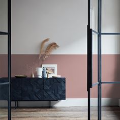 an empty room with a sideboard and vases on it