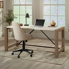 a white desk with a laptop on it in front of two windows and a potted plant