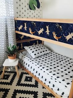 a bedroom with a bunk bed and black and white patterned wallpaper on the walls