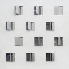 a white wall with many square windows on it