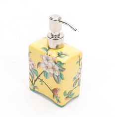 a yellow soap dispenser with flowers painted on it