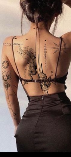 the back of a woman's body with tattoos on it