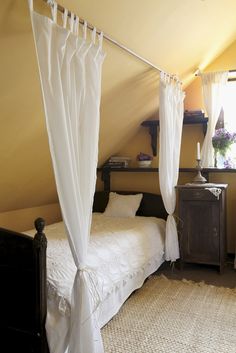 a white bed sitting under a window in a bedroom