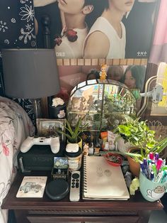 a desk with various items on it and a lamp next to the wall behind it