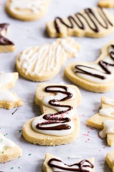 cookies with white icing and chocolate drizzled on them