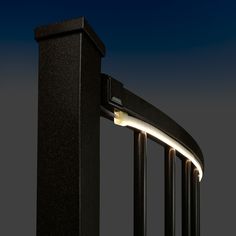 an image of a light that is on the side of a fence post at night