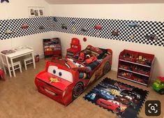 a bedroom with cars bedding and toys in it