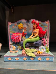 the little mermaid figurine is on display