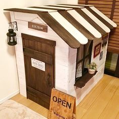 a dog house made out of wood with a sign on the door that says open