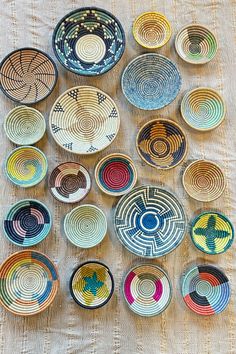 many plates are arranged in the shape of an abstract design on a tablecloth with white linen