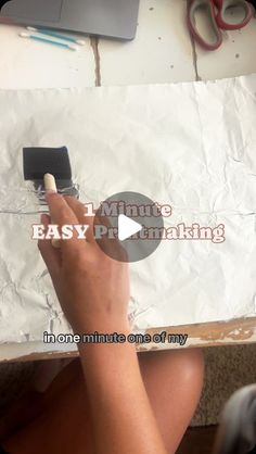 someone is using a brush to paint the paper on top of a piece of cardboard