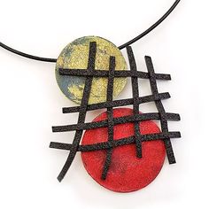 two pendants with black and red designs on them