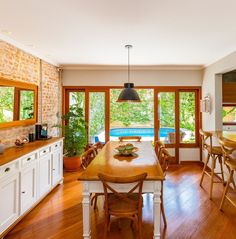 a dining room with wooden floors and large windows