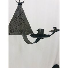 a metal lamp hanging from the ceiling with a hat on it's back end