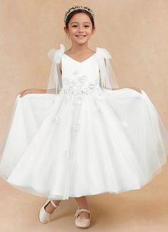 Minia is a charming flower girl matte satin A-line dress that features delicate tulle fabric that creates a whimsical, fun, and flowy effect. Her V-neckline is adorned with bow details on the shoulders that add an extra touch of sweetness and charm. The full A-line silhouette ensures a graceful and twirl-worthy appearance. Satin Flower Girl Dresses, Burgundy Flower Girl Dress, Tea Length Flower Girl Dress, Tea Length Tulle, Satin Flower Girl Dress, Maternity Bridesmaid Dresses, Military Ball Dresses, Ivory Flower Girl, Special Event Dresses