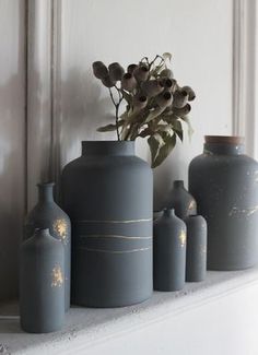 several vases are lined up on a shelf