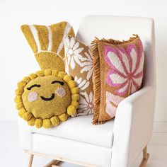 a chair with two pillows on it and a stuffed lion sitting next to each other