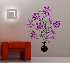 a living room with a red couch and wall decal that has purple flowers in it