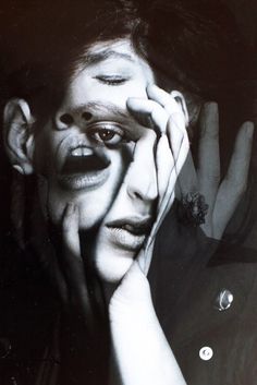 a black and white photo of a woman with her hands on her face