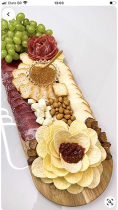 a wooden platter filled with different types of food and fruit on top of it