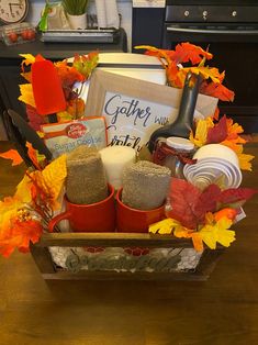 a basket filled with fall items on top of a wooden table