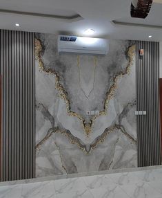 a large marble wall in a room with wood paneling on the walls and an air conditioner hanging from the ceiling