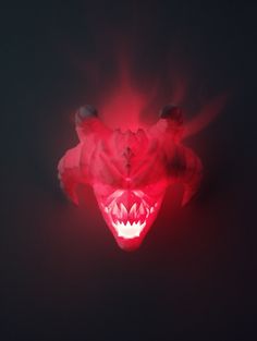 a red light shining on the face of a bear with its mouth open and teeth out