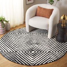 a white chair sitting on top of a wooden floor next to a black and white rug