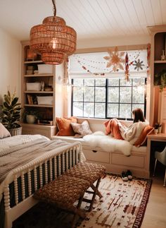 a woman sitting on a window seat in a bedroom