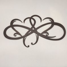 an ornamental design on a white surface with black ink in the shape of two intertwined hearts