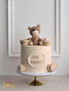 a baby shower cake with a teddy bear on top