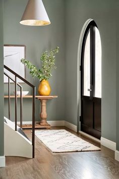 an entryway with green walls and wooden floors