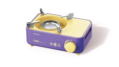 a purple and yellow toaster sitting on top of a white table next to a frying pan