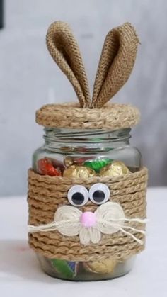 a mason jar filled with candy and an easter bunny face made out of twine