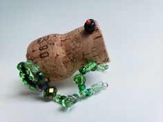 a wine cork with green glass beads on it