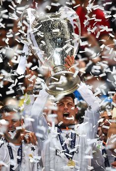 the real madrid players celebrate with the trophy