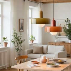 a living room filled with furniture and lots of light fixture hanging over it's table