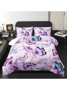 a bed with purple butterflies on it in a white and black room, next to a couch