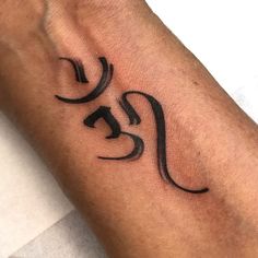 a man's arm with a tattoo on it that has an omen symbol