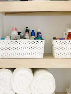 bathroom shelves with towels, soaps and lotion in baskets next to each other