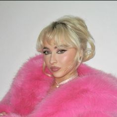 a woman wearing a pink fur coat