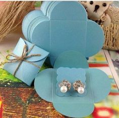 there are two pairs of earrings on top of the box and one pair of pearls