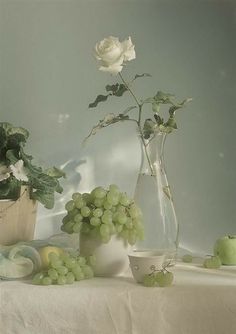 a vase filled with white flowers sitting on top of a table next to other items