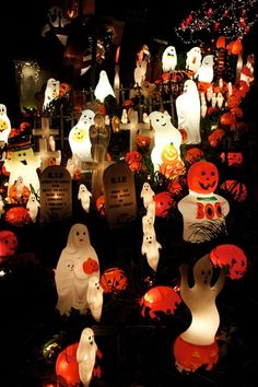 many halloween decorations are lit up in the dark with ghost and pumpkins on them