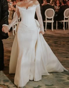 a bride and groom hold hands as they walk down the aisle