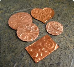 four copper hearts on a granite surface