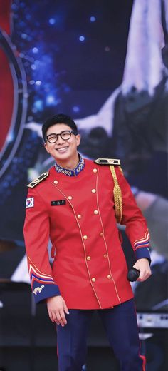 a man in a red uniform standing on stage