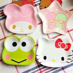 hello kitty and frog shaped plates on a checkered tablecloth