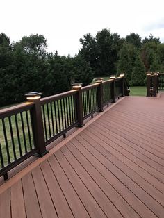 a wooden deck with three lights on each side and trees in the backround