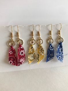 These earrings are handmade with a piece of bandanna fabric in there different colors red, blue, and yellow. Each earring has a small charm hanging in the gold colored circle. These earrings are very light weight and measure approximately 2 1/4 inches long from the earring hook to bottom of fabric. If you have any questions or concerns feel free to contact owner and designer at hannahsjeweltique@gmail.com Attention: color may look different on your electronic device than another Hanky Code, Western Earrings, Fabric Earrings, Earring Hook, Jewelry Techniques, Small Charms, Ear Rings, Fabric Jewelry, Diy Fabric